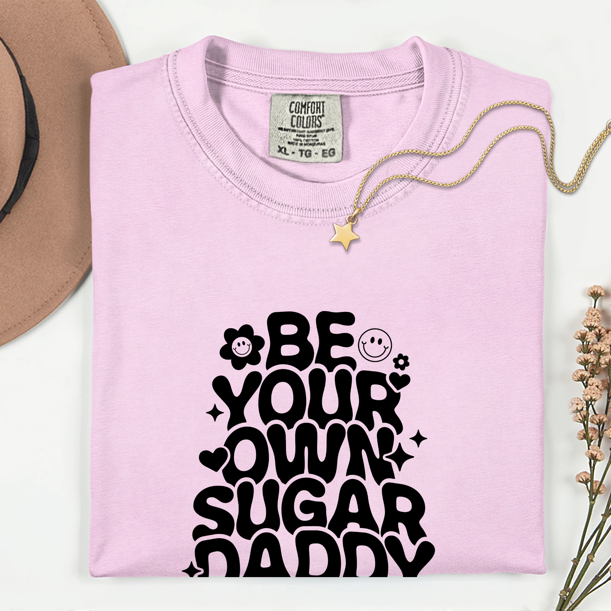 Pink sweatshirt with 'Be your own sugar daddy' text on a white background