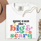White t-shirt with colorful text 'you can do big & scary' on a white background