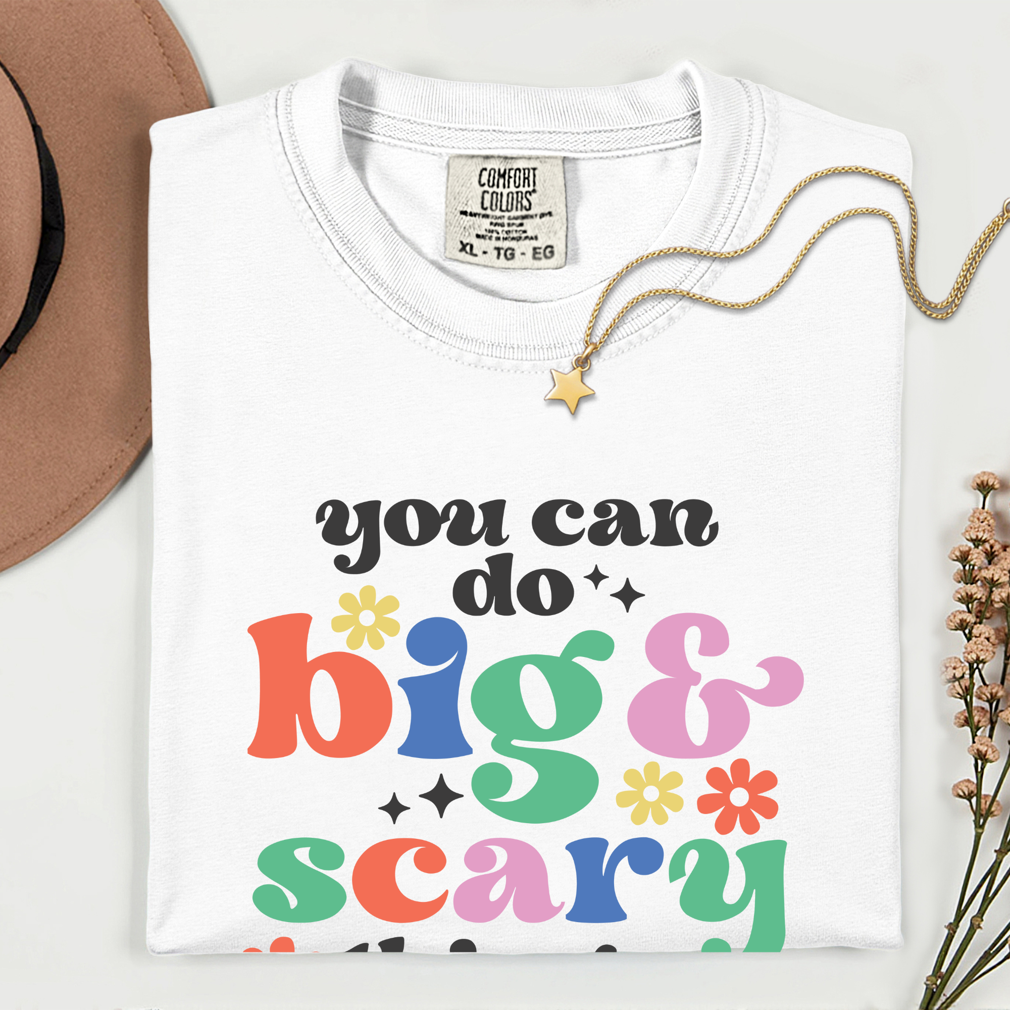 White t-shirt with colorful text 'you can do big & scary' on a white background