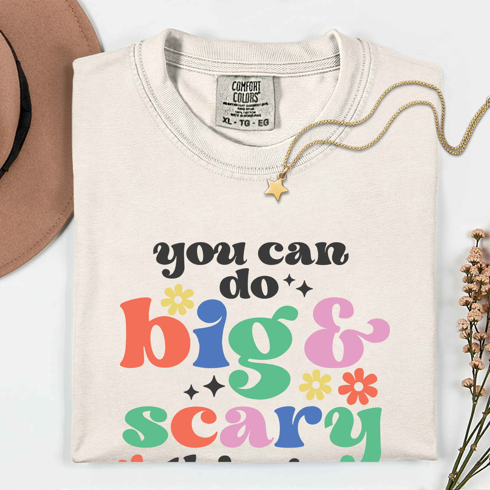 Beige sweatshirt with colorful text 'you can do big & scary' on a white background
